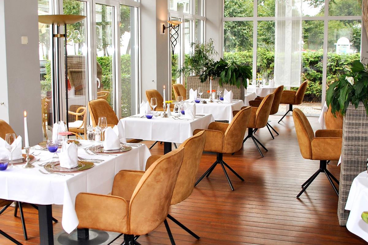 Stilvolles Restaurant Ruiani im Grand Hotel Binz mit elegant gedeckten Tischen, gemütlichen Stühlen und heller Fensterfront.