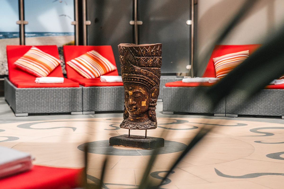 Asian-inspired statue as decoration in the spa with beach motif in background